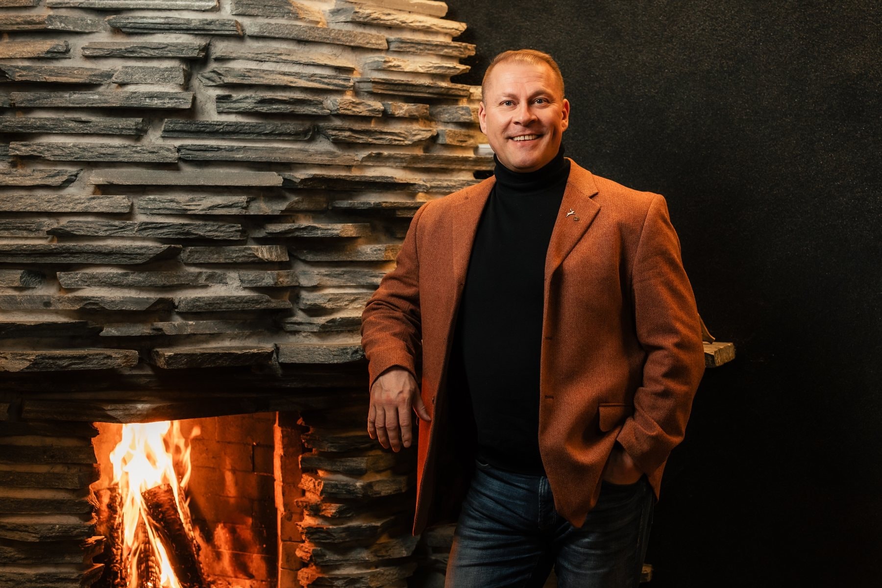 Henry Hynynen by the fireplace of a Lapland lodge